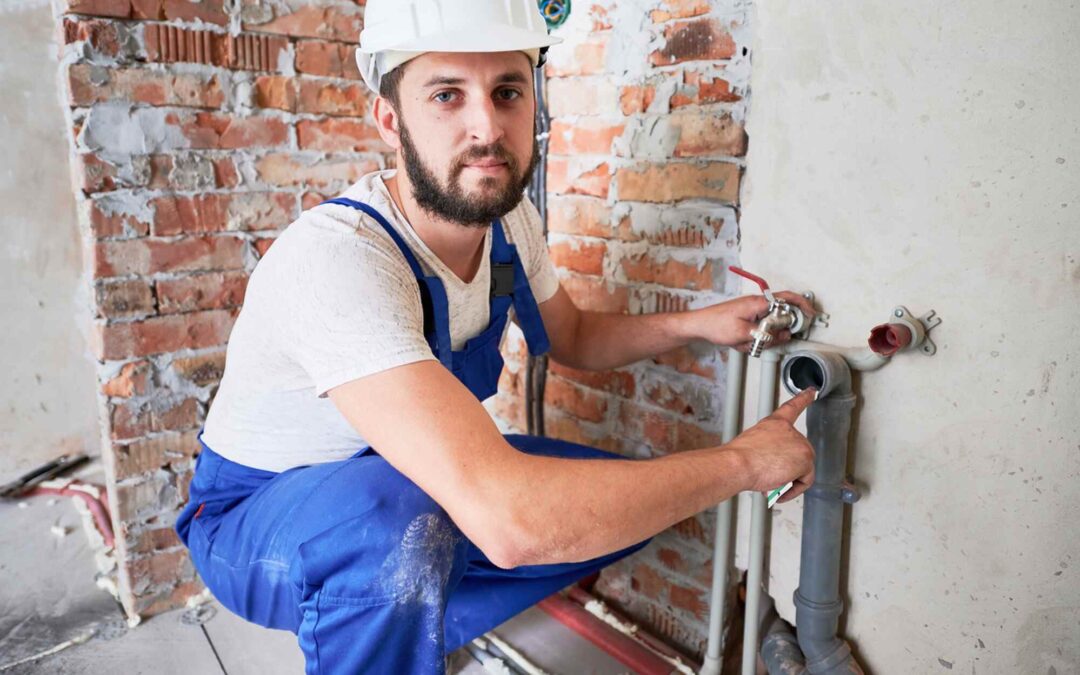 professional plumber repairing a leaking water pipe