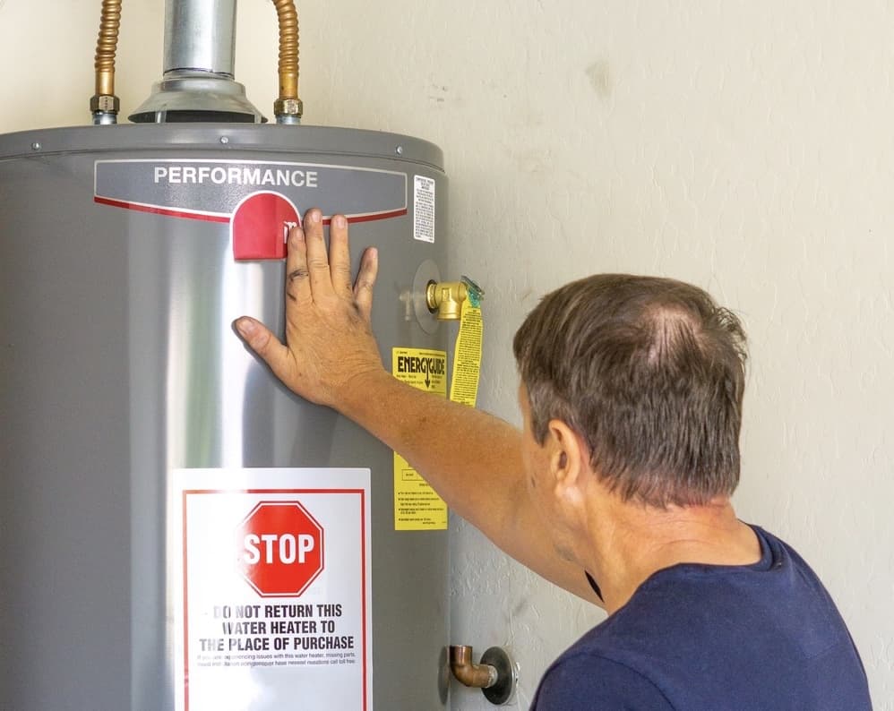 male with hand on a newly installed water heater